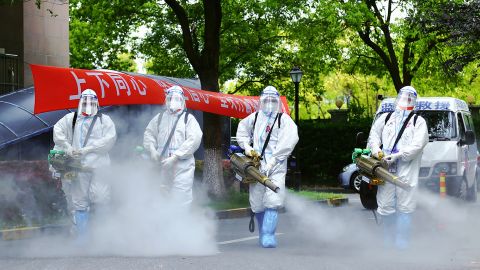 Covid workers disinfect a residential community under lockdown in Shanghai in April.