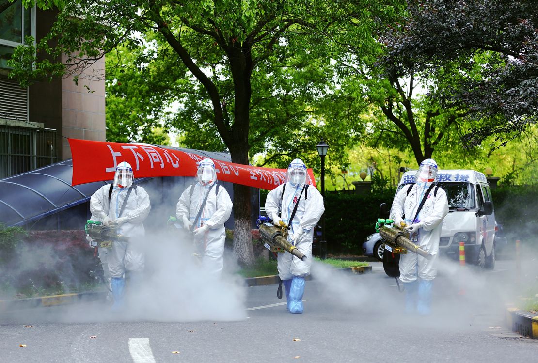 Covid workers disinfect a residential community under lockdown in Shanghai in April.