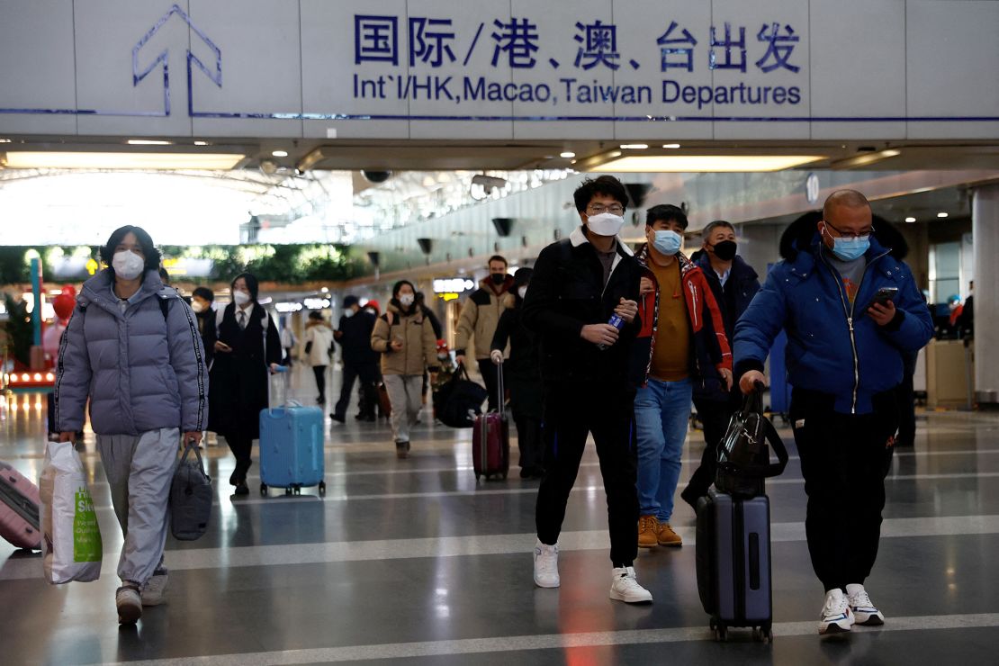 Travellers walk with their luggage at Beijing Capital International Airport in Beijing, China December 27, 2022.