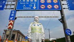 A transit officer, wearing a protective gear, controls access to a tunnel in the direction of Pudong district in lockdown as a measure against the Covid-19 coronavirus, in Shanghai on March 28, 2022. 