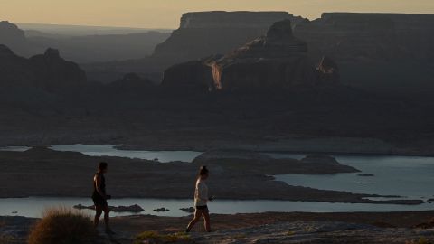 Pengunjung menyaksikan matahari terbit di atas Danau Powell yang menyusut dari Alstrom Point di Big Water, Utah, pada bulan September.