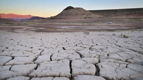 A vehicle drives past the dry, cracked lake bed of drought-stricken Lake Mead in September.