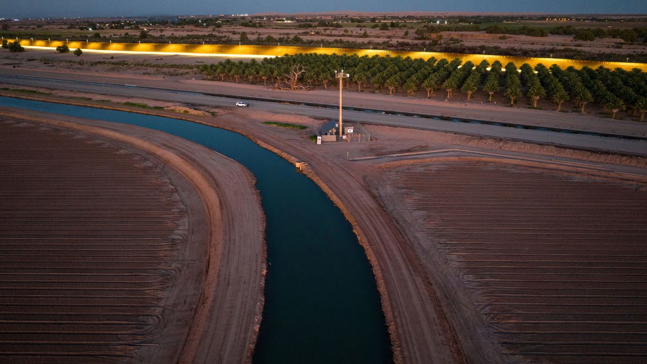 The All-American Canal flows near a section of the US-Mexico border in September. The canal, which draws water from the Colorado River, irrigates US farms along the Arizona and California borderlands with Mexico. 