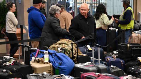 यात्री मंगलवार को कैलिफोर्निया के हॉलीवुड बरबैंक एयरपोर्ट पर अपना सामान ढूंढते हुए। 