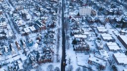 In this aerial photo, an excavator (C, bottom) makes its way up Richmond Avenue in Buffalo, New York, on December 28, 2022. - The monster storm that killed dozens in the US over the Christmas weekend continued to inflict misery on New York state and air travelers nationwide, as stories emerged of families trapped for days during the "blizzard of the century." The number of deaths attributed to the winter storm rose to more than 50 after officials confirmed three more fatalities in western New York's Erie County, the epicenter of the crisis.
