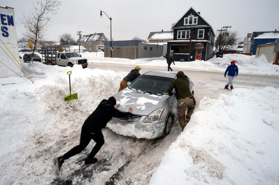 People help push a car out of snow in Buffalo on Tuesday, December 27.