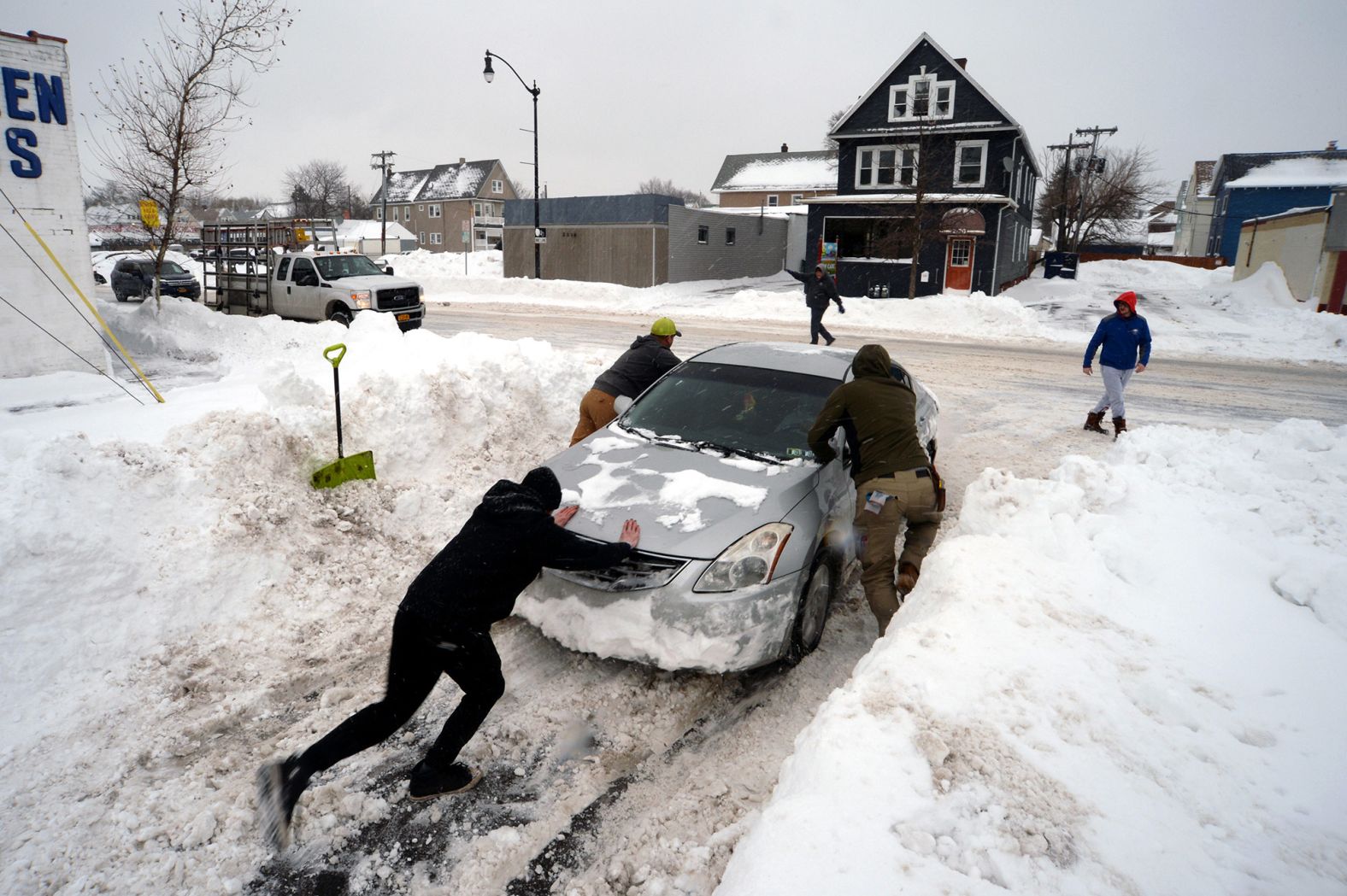 People help push a car out of snow in Buffalo on Tuesday, December 27.