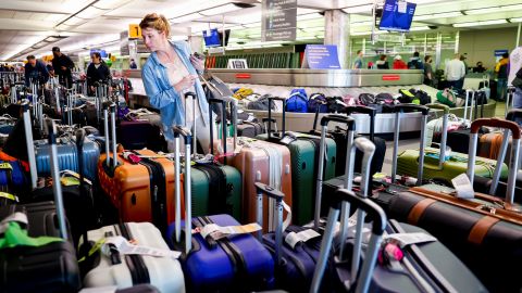 A traveler searches for a suitcase in a baggage holding area for Southwest Airlines at Denver International Airport on December 28, 2022.
