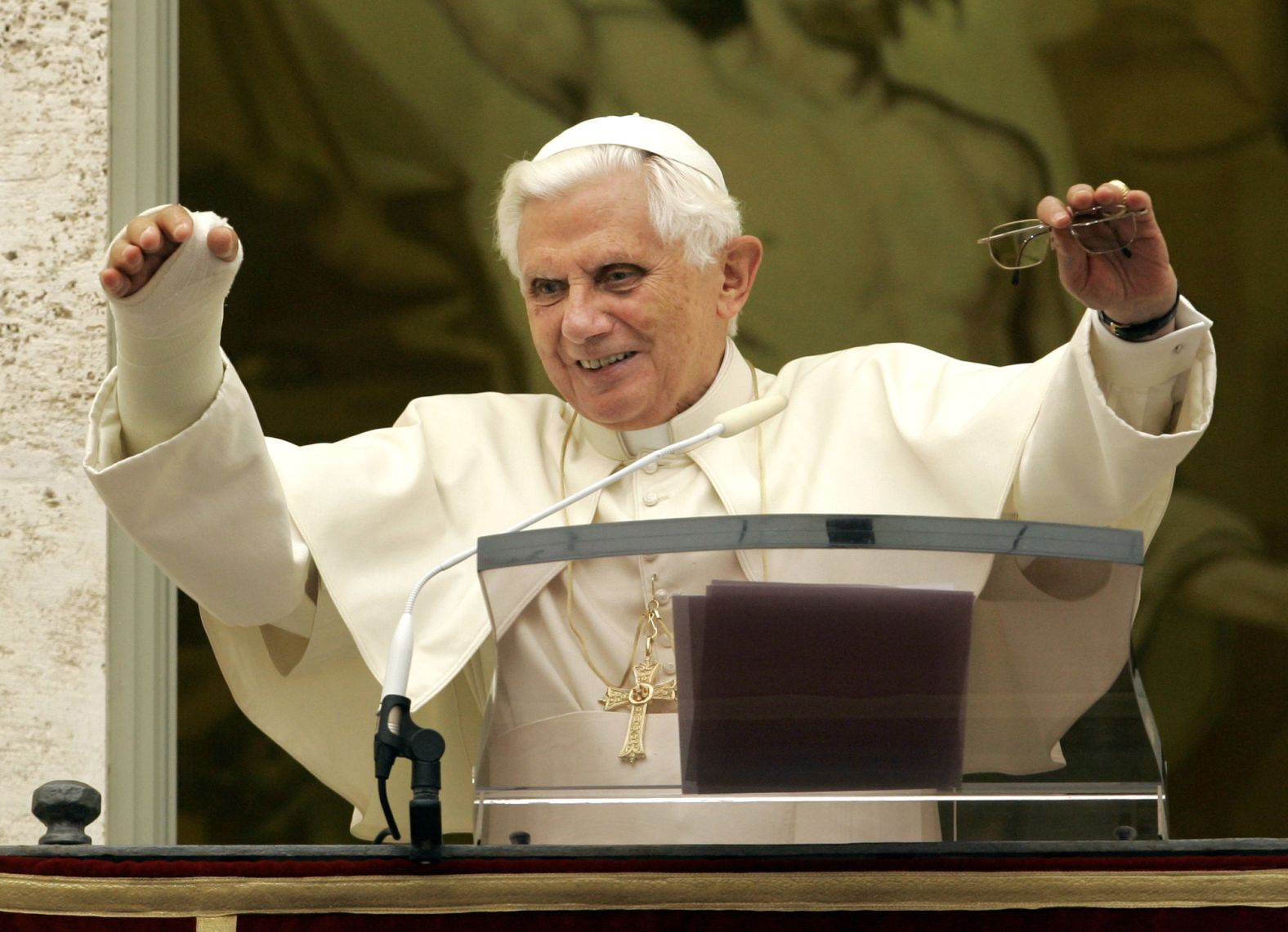 The Pope waves to faithful from a window of his summer residence in Castel Gandolfo, on the outskirts of Rome, during his weekly general audience in August 2009. His right arm was in a cast after he fell and broke his right wrist while vacationing a month earlier.