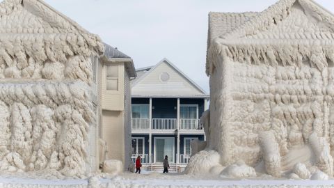 People walk among the frozen houses of Crystal Beach.