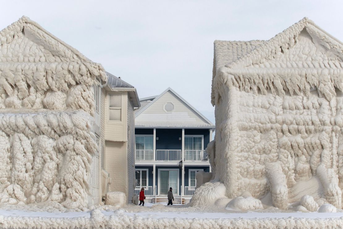 People walk between frozen homes in Crystal Beach.