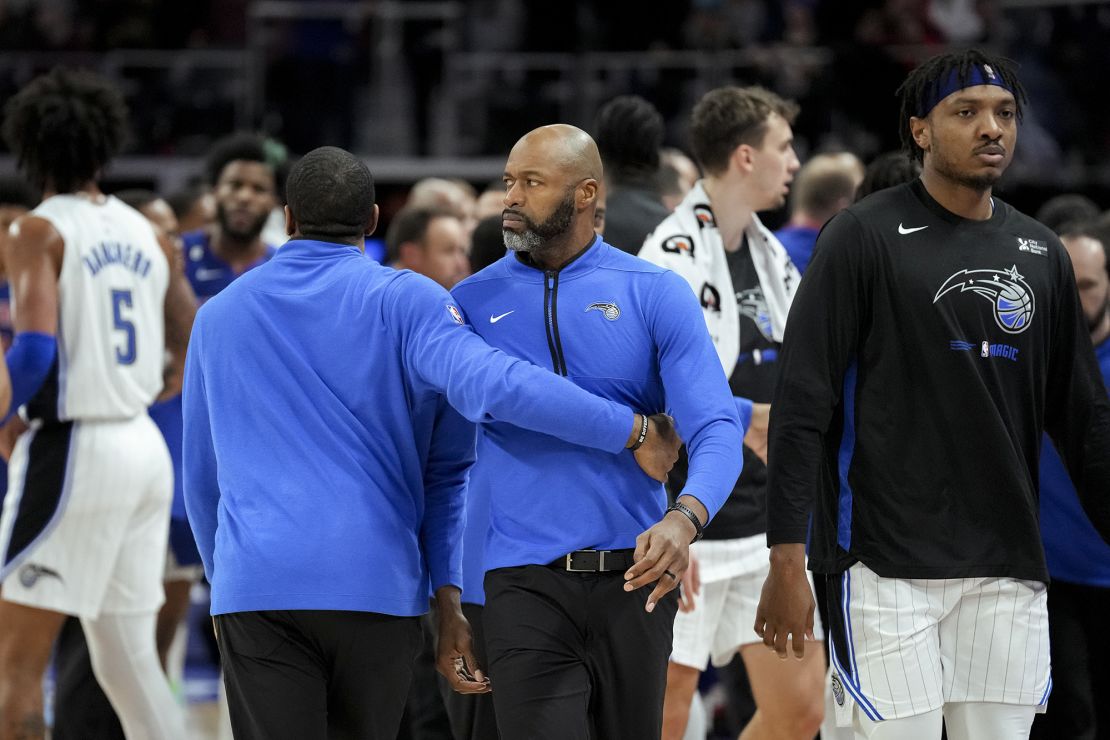 Orlando Magic head coach Jamahl Mosley is held back against the Detroit Pistons.