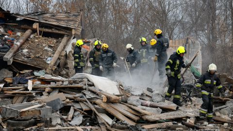 Rescuers dig through the rubble of a house hit by a Russian missile strike.