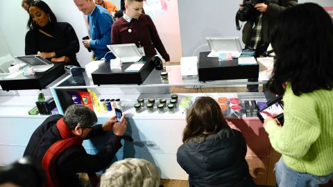 Members of the media take pictures before the opening of the first legal cannabis dispensary in New York City, on December 29, 2022.