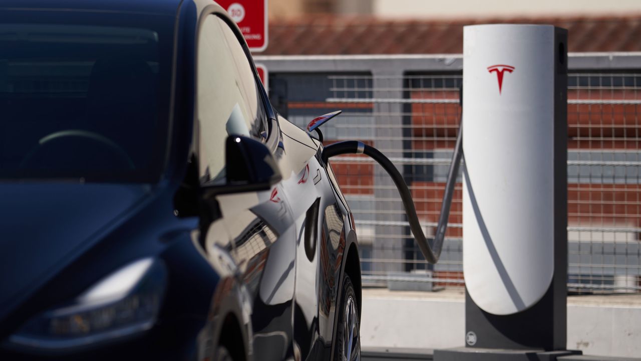 A Tesla vehicle is plugged into a Tesla charging station in a parking lot on September 22, 2022 in Santa Monica, California. (Photo by Allison Dinner/Getty Images)