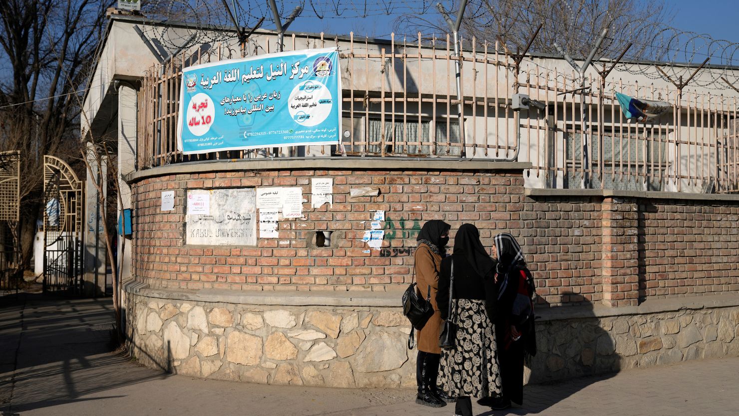 Afghan women students stand outside the Kabul University in Kabul, Afghanistan, on Wednesday, December 21, 2022. 