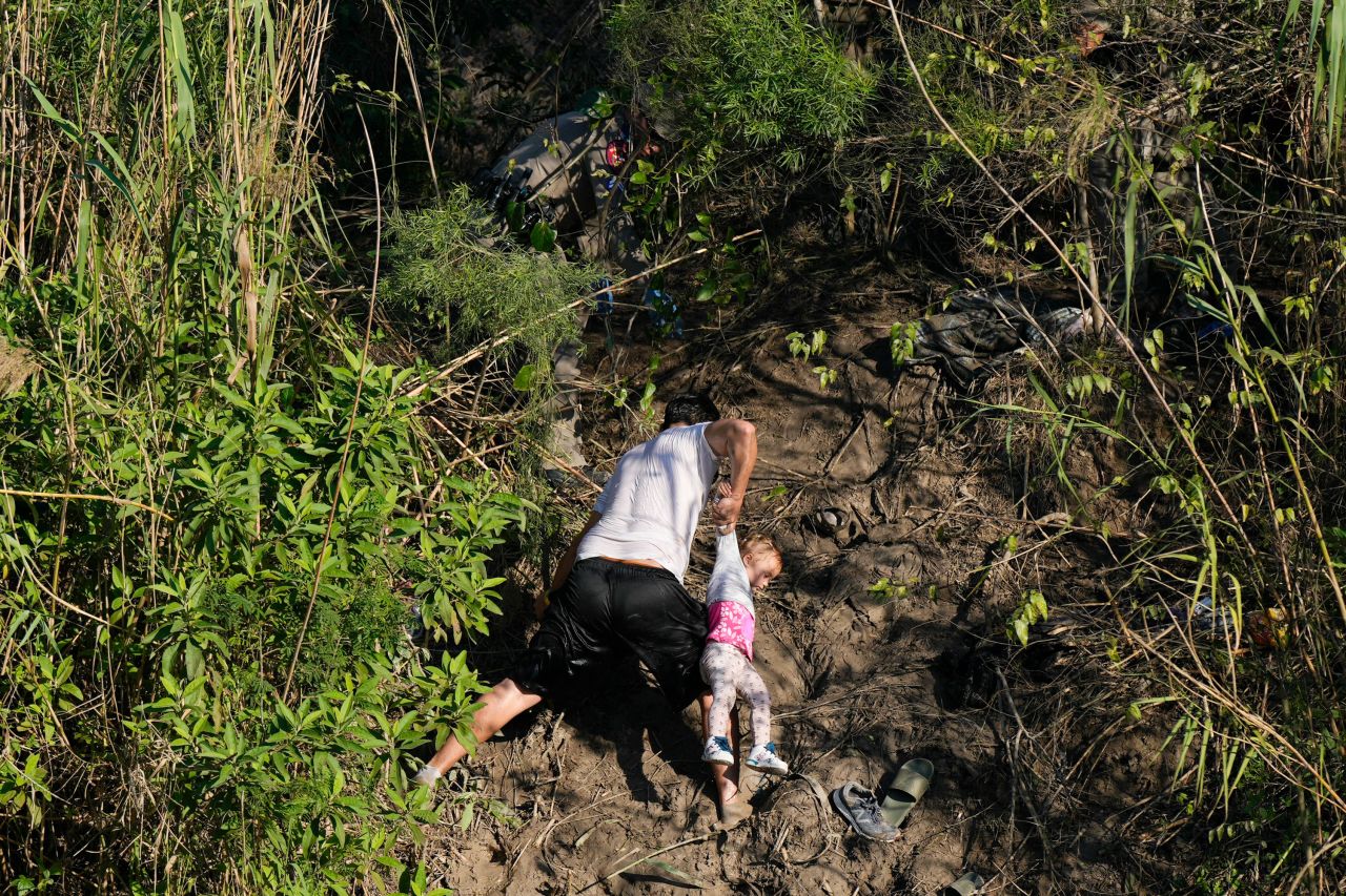 After crossing the Rio Grande from Matamoros, Mexico, a Venezuelan migrant holds a child as he climbs the river bank onto US territory on Thursday, December 22. <a href="http://www.cnn.com/2022/12/14/world/gallery/el-paso-migrants-border-crossings/index.html" target="_blank">An increase in border crossings</a> came before the scheduled end of Title 42, a policy that officials have been relying on to kick many migrants out of the United States. The Supreme Court now says <a href="https://www.cnn.com/2022/12/27/politics/supreme-court-title-42/index.html" target="_blank">that policy will remain in effect</a> while legal challenges play out into next year.