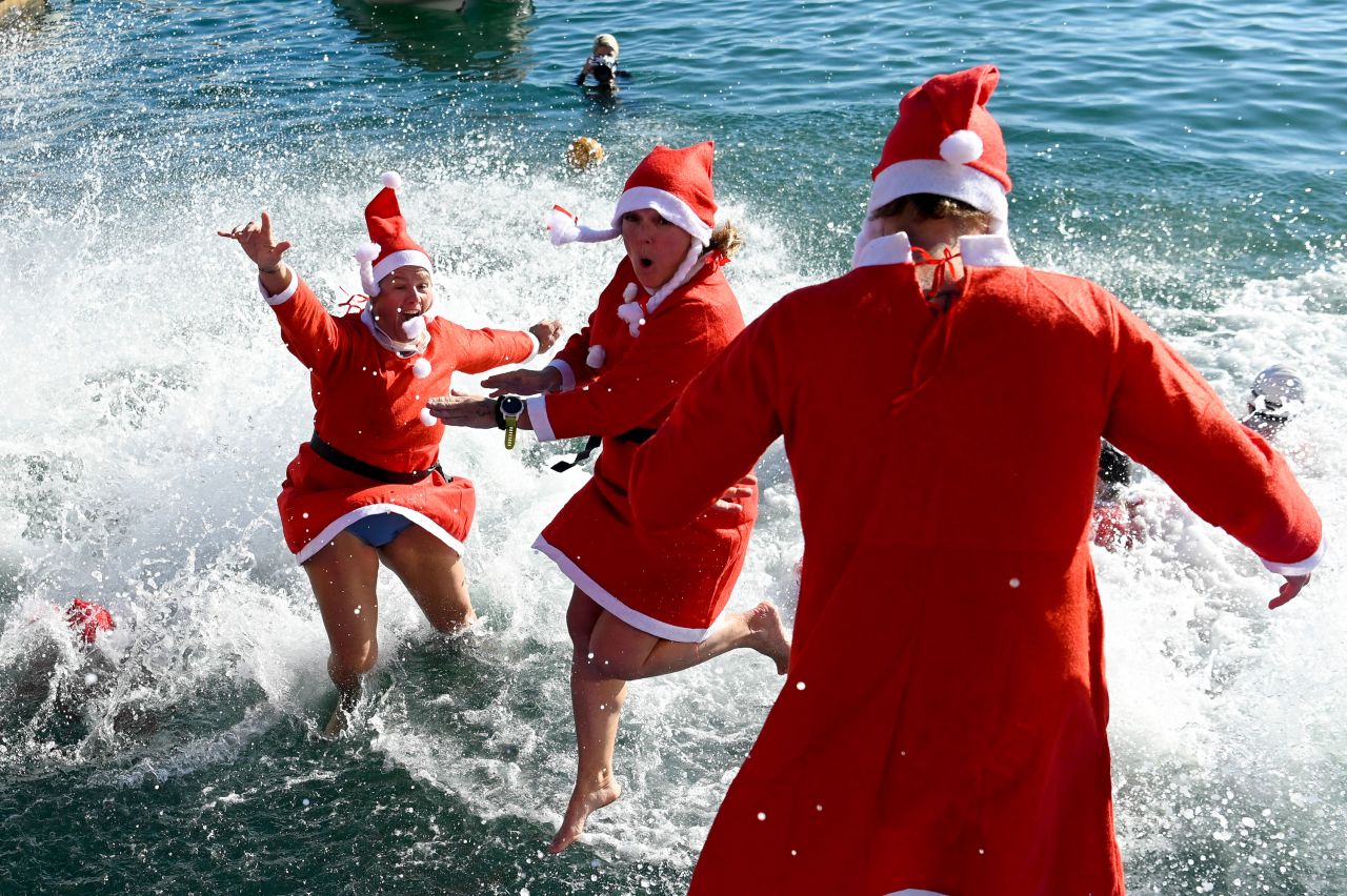 People wearing Santa Claus costumes jump into the water during the 113th edition of the Christmas Cup swimming race in Barcelona, Spain, on Sunday, December 25.