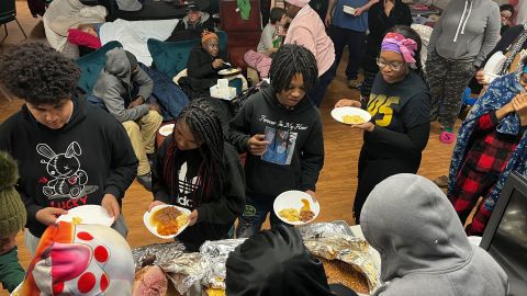 Families weather a snowstorm line up for food at the Spirit of Truth Urban Ministry in Buffalo, New York.