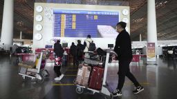 People walk with their suitcases through a departure lobby of Beijing Capital International Airport on Dec. 27, 2022. 