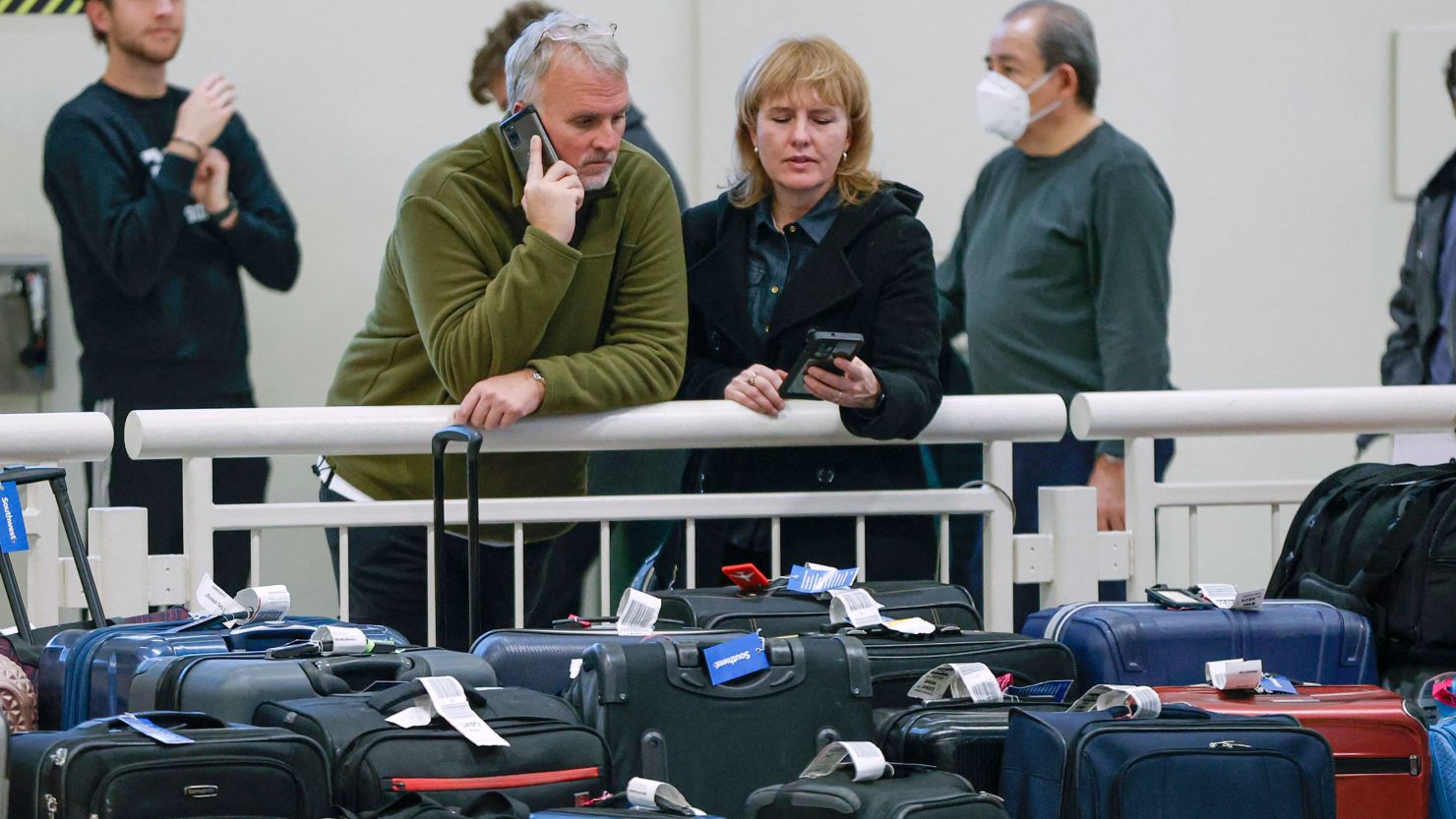 Stranded Southwest Airlines passengers looks for their luggage in the baggage claim area at Chicago Midway International Airport in Chicago, Illinois, on December 28, 2022. 