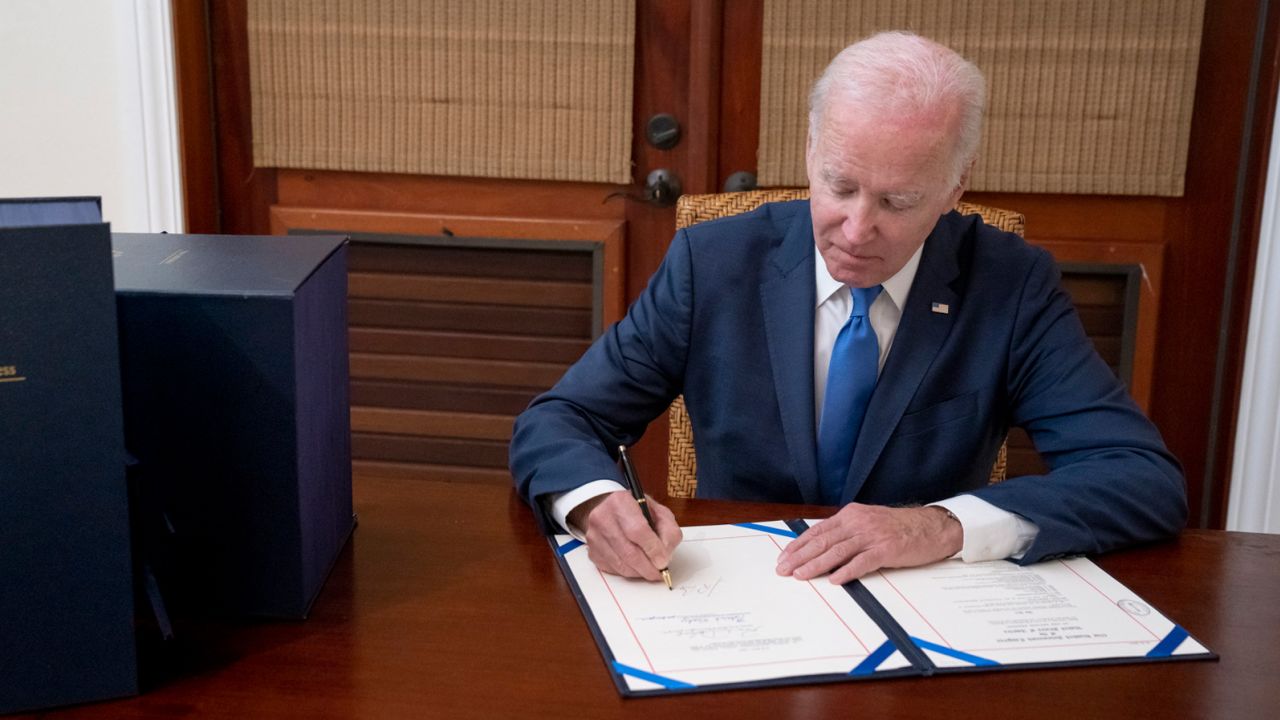 President Joe Biden signs the bipartisan omnibus bill.