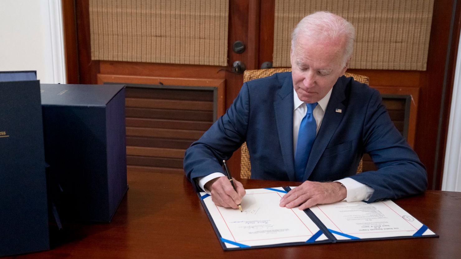 President Joe Biden signs the bipartisan omnibus bill.