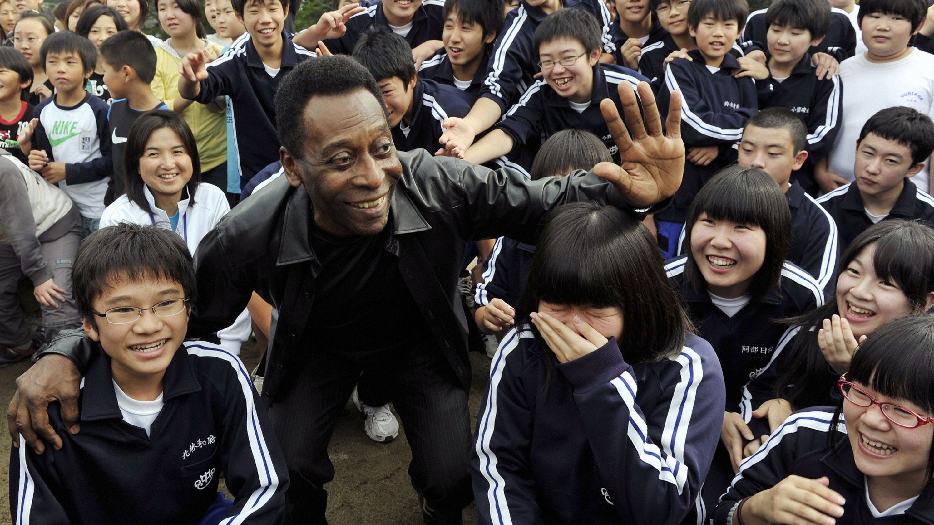 Pelé poses with children in Natori, Japan, in 2011, following an earthquake and tsunami in the region. He was there to help promote the 2014 World Cup, which took place in Brazil.