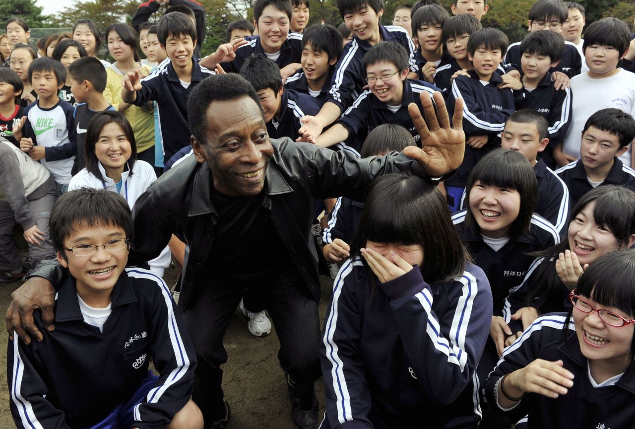 Pelé poses with children in Natori, Japan, in 2011, following an earthquake and tsunami in the region. He was there to help promote the 2014 World Cup, which took place in Brazil.