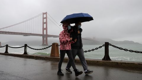 A couple walks near the Golden Gate Bridge as rain hits San Francisco this week. 
