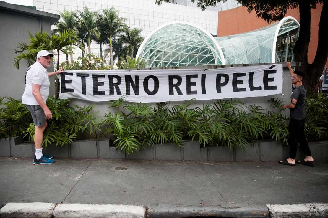 Fans hang a banner reading "Eternal king Pelé" outside the Albert Einstein Hospital where Brazilian soccer legend Pelé was hospitalized before his death in Sao Paulo, Brazil, December 29, 2022. 