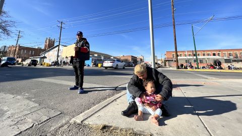 Anthony Blanco holds a hand-written sign asking for a job while his wife, Glenda Matos, plays with Brenda in the streets of El Paso, Texas.