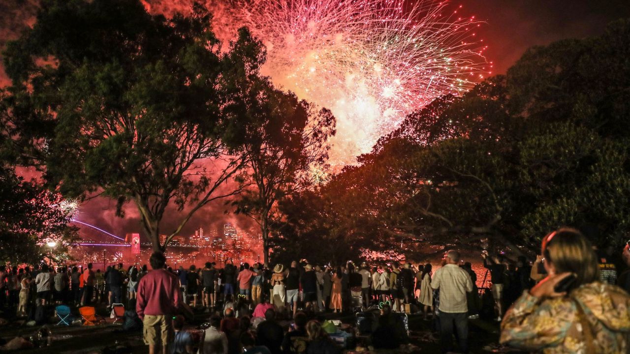 SYDNEY, AUSTRALIA - DECEMBER 31: People watch 9pm fireworks  on December 31, 2022 in Sydney, Australia. Revelers turned out in droves to celebrate the arrival of the new year, the first since pandemic restrictions were completely removed in early 2022. (Photo by Roni Bintang/Getty Images)