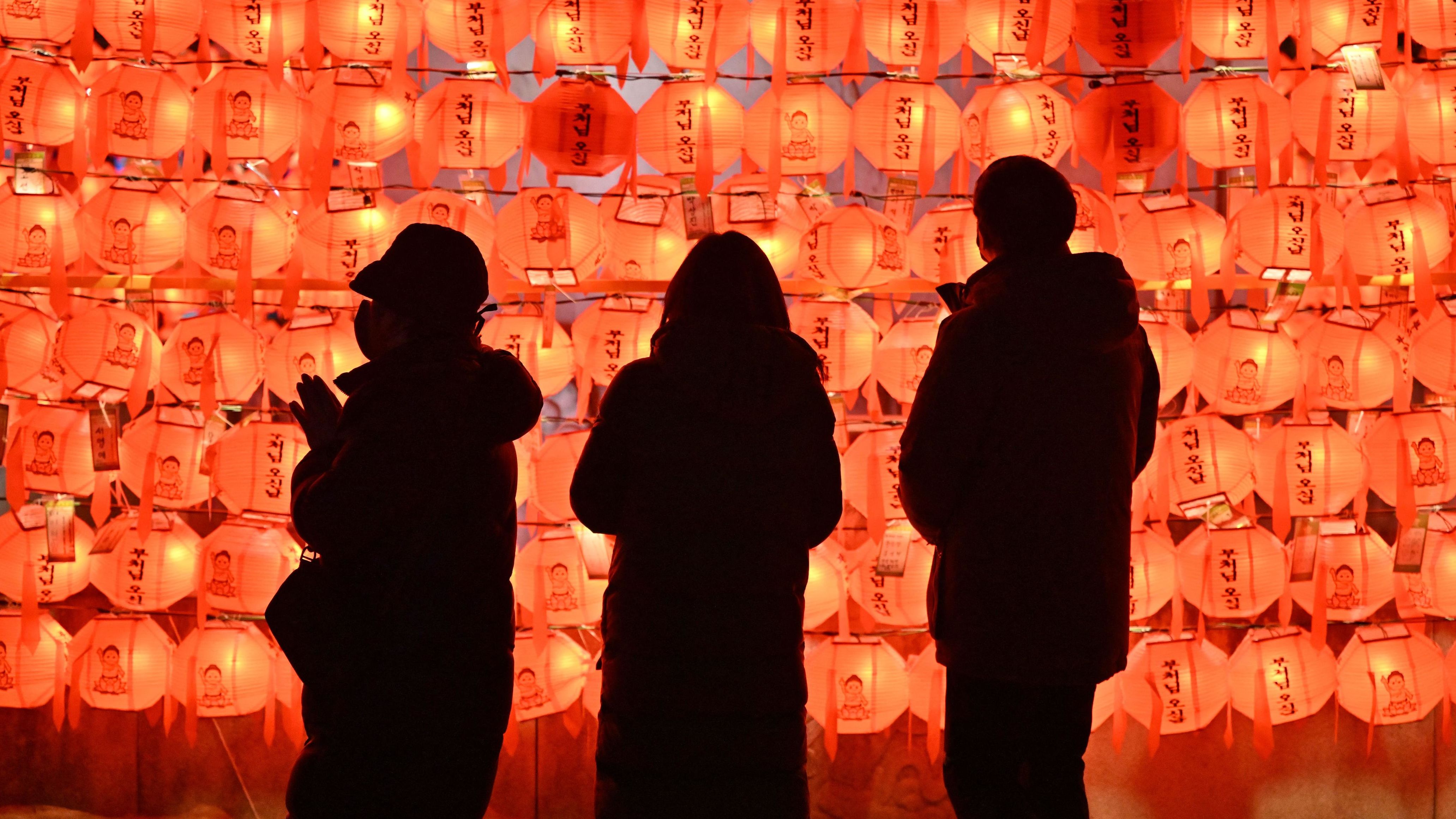 People pray in front of lotus lanterns during celebrations in Seoul, South Korea.