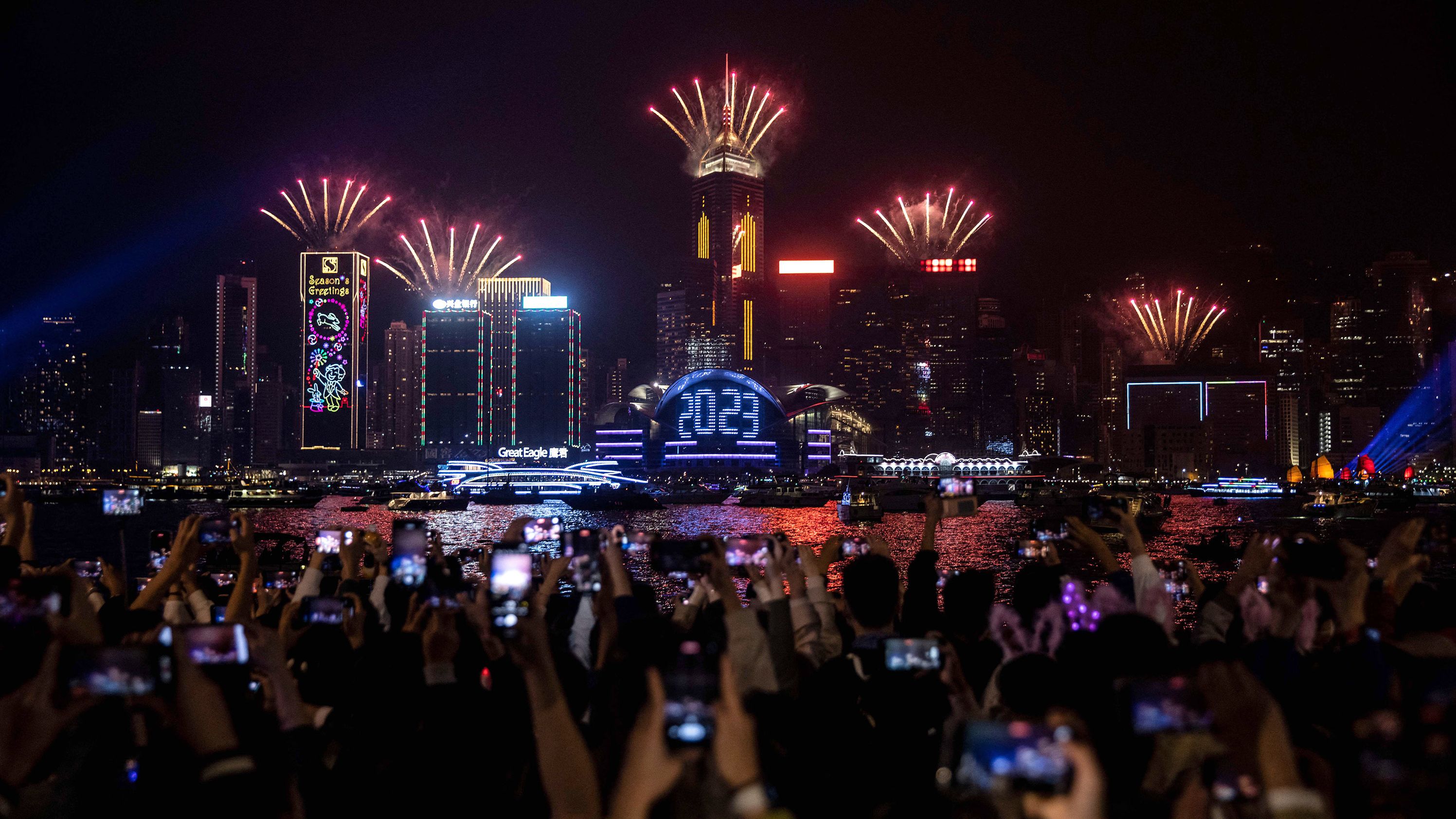 New Year's revelers watch a fireworks and laser show in Hong Kong.