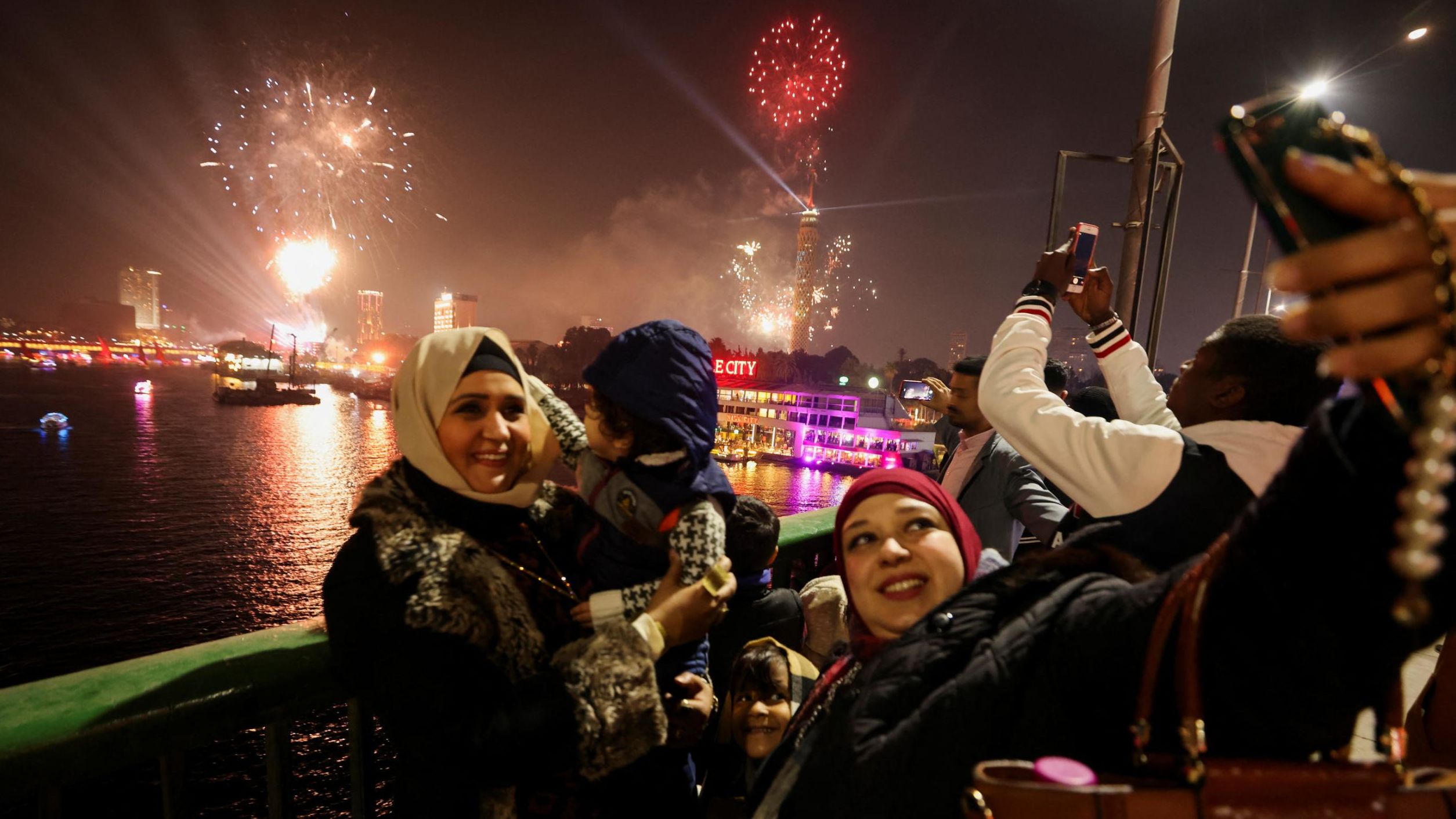 People take a selfie as fireworks explode over Cairo.