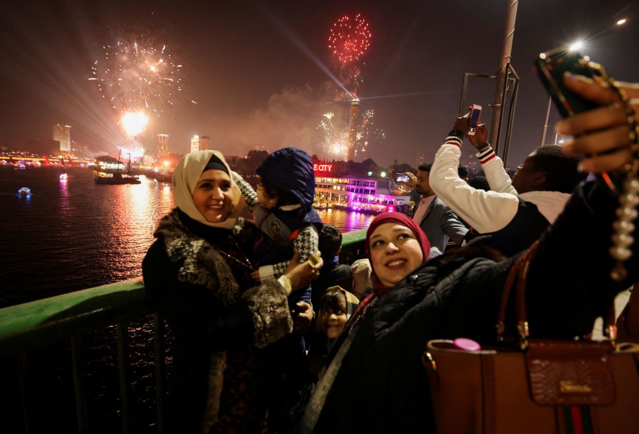 People take a selfie as fireworks explode over Cairo.