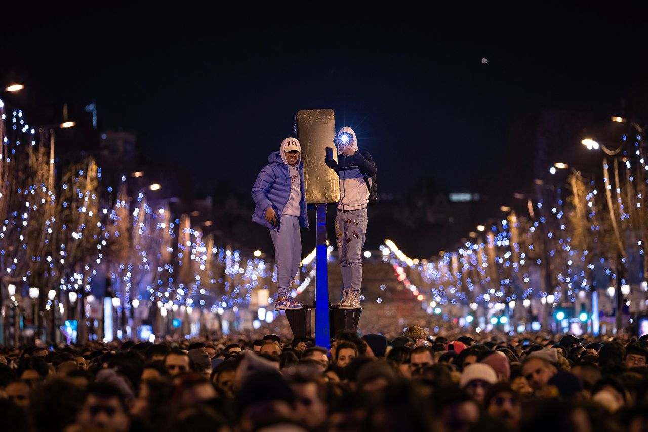 People watch a sound and light show projected on the Arc de Triomphe in Paris.