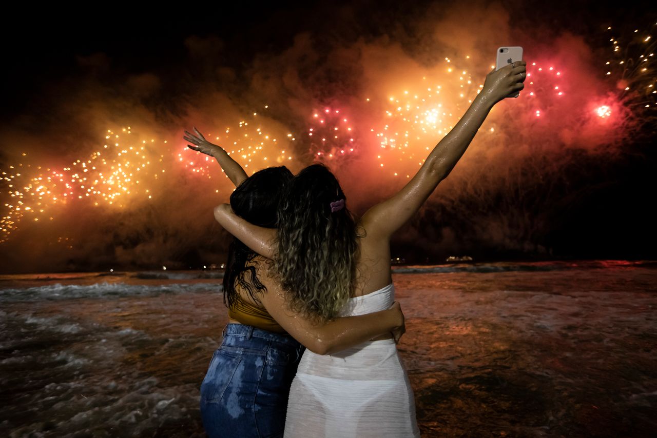 People watch fireworks explode over Copacabana Beach in Rio de Janeiro, Brazil.