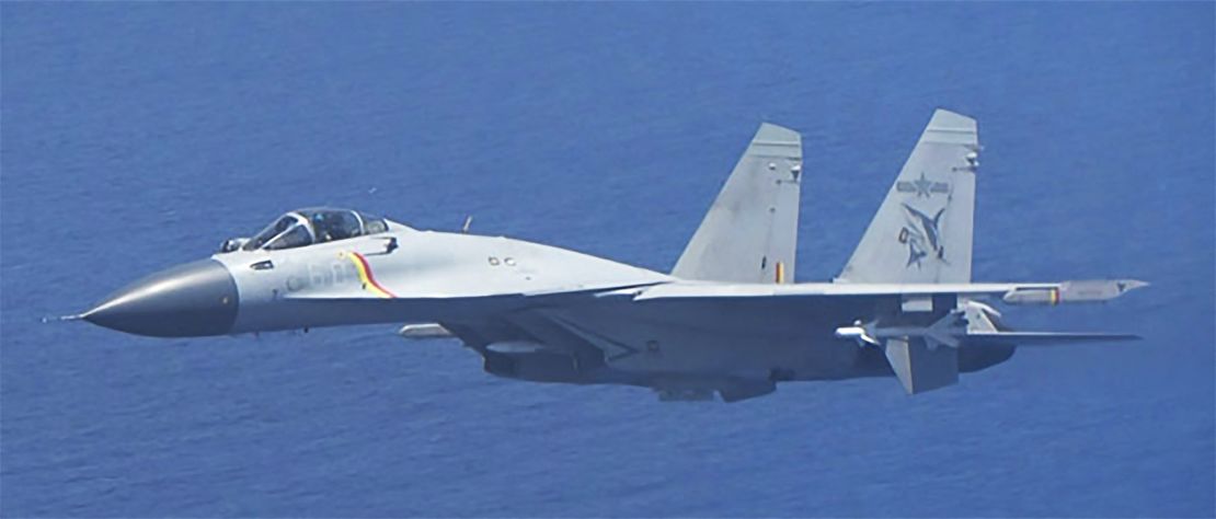 This handout photo from Japan's Ministry of Defense shows a J-15 fighter jet making an unusual approach to a Japan Maritime Self-Defense Force P-3C patrol aircraft.