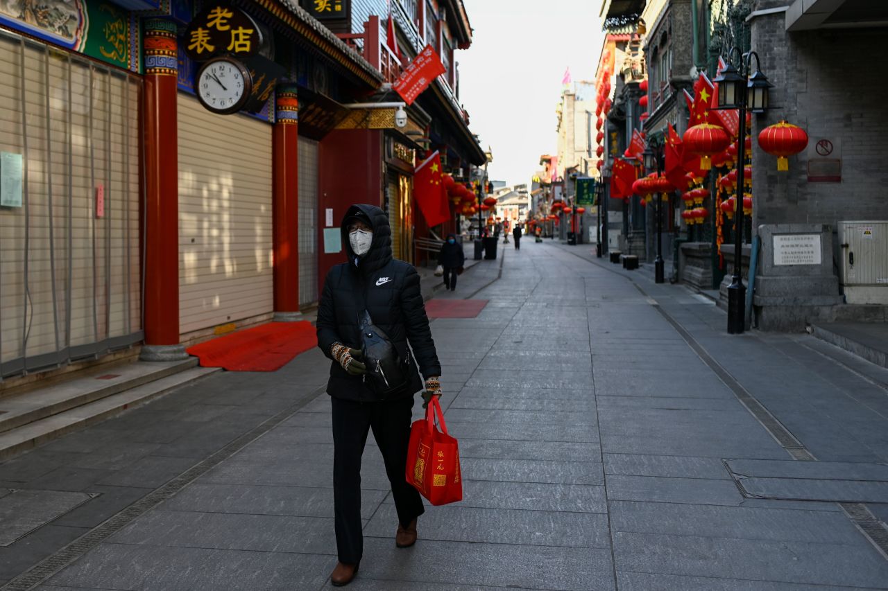 A woman walks past closed shops and businesses in Beijing on February 4, 2020.