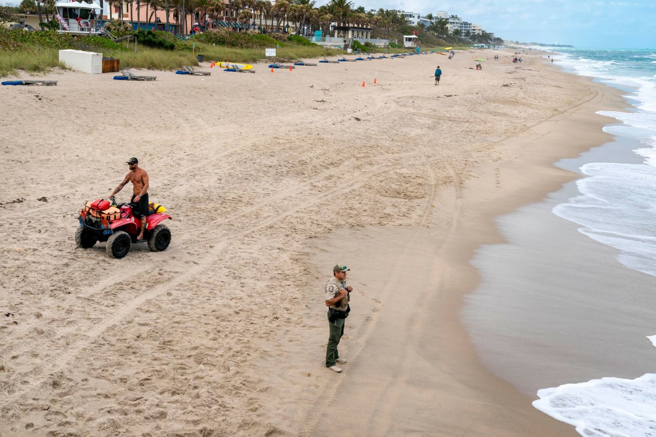 Lake Worth Beach lifeguard captain Michael Tricarico, left and FWC officer Ryan Ames clear the beach on March 20 in Lake Worth, Florida. 