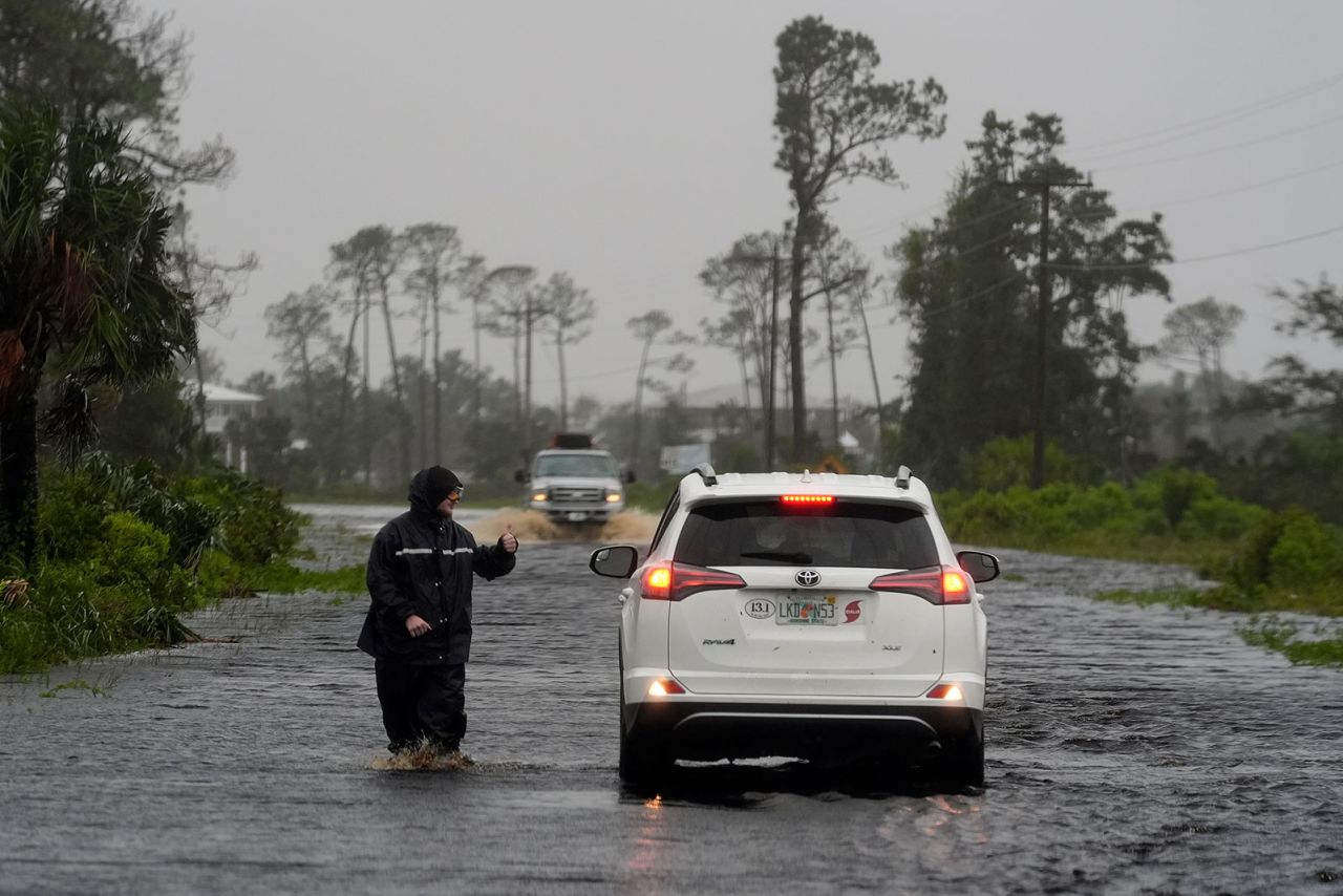 A man walks through storm surge on the flooded road into Horseshoe Beach, Florida, on  Monday, August 5. 