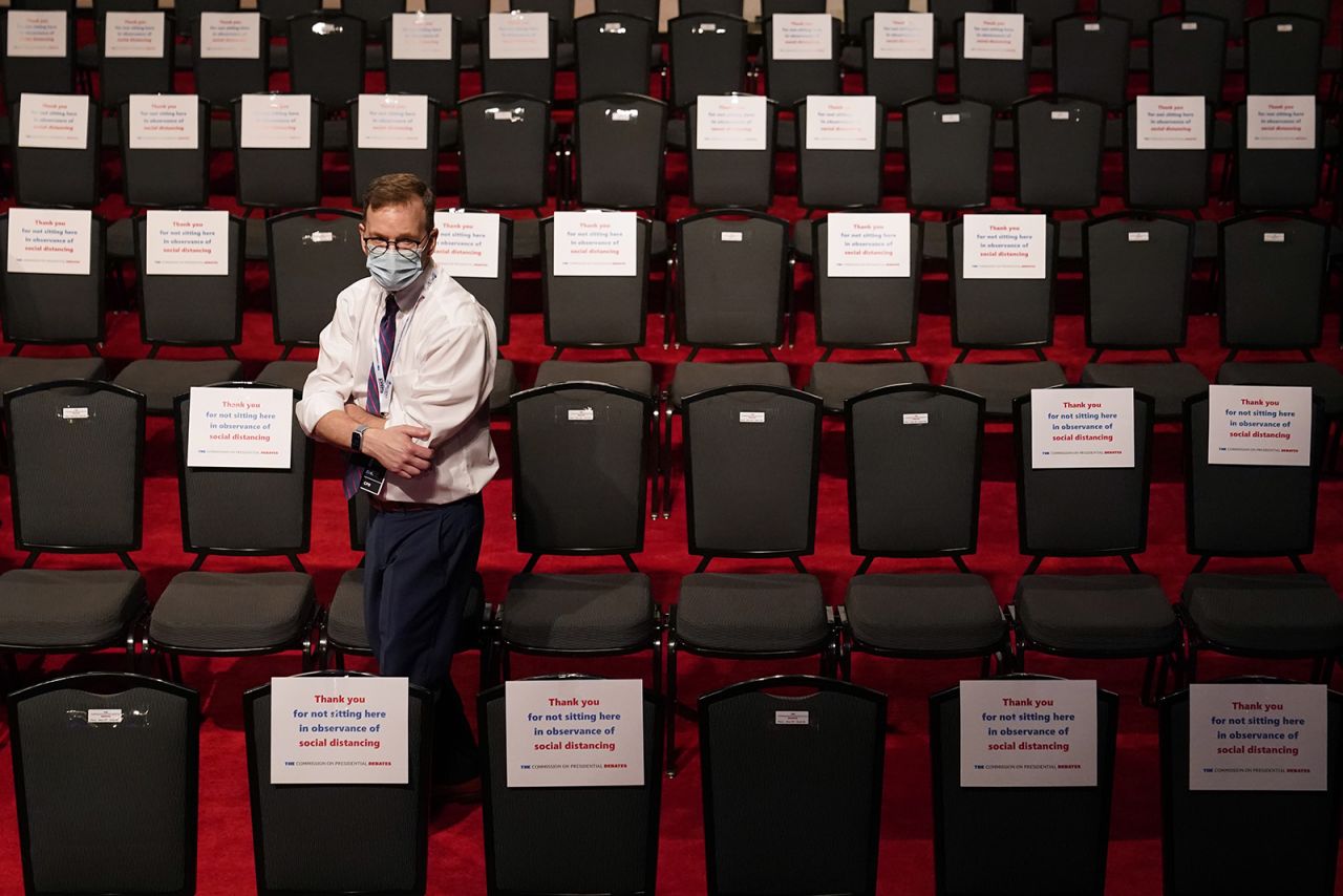 A debate official walks past spectator seating marked with signs observing social distancing requirements for the final debate between President Donald Trump and Democratic presidential candidate Joe Biden at Belmont University on Thursday.