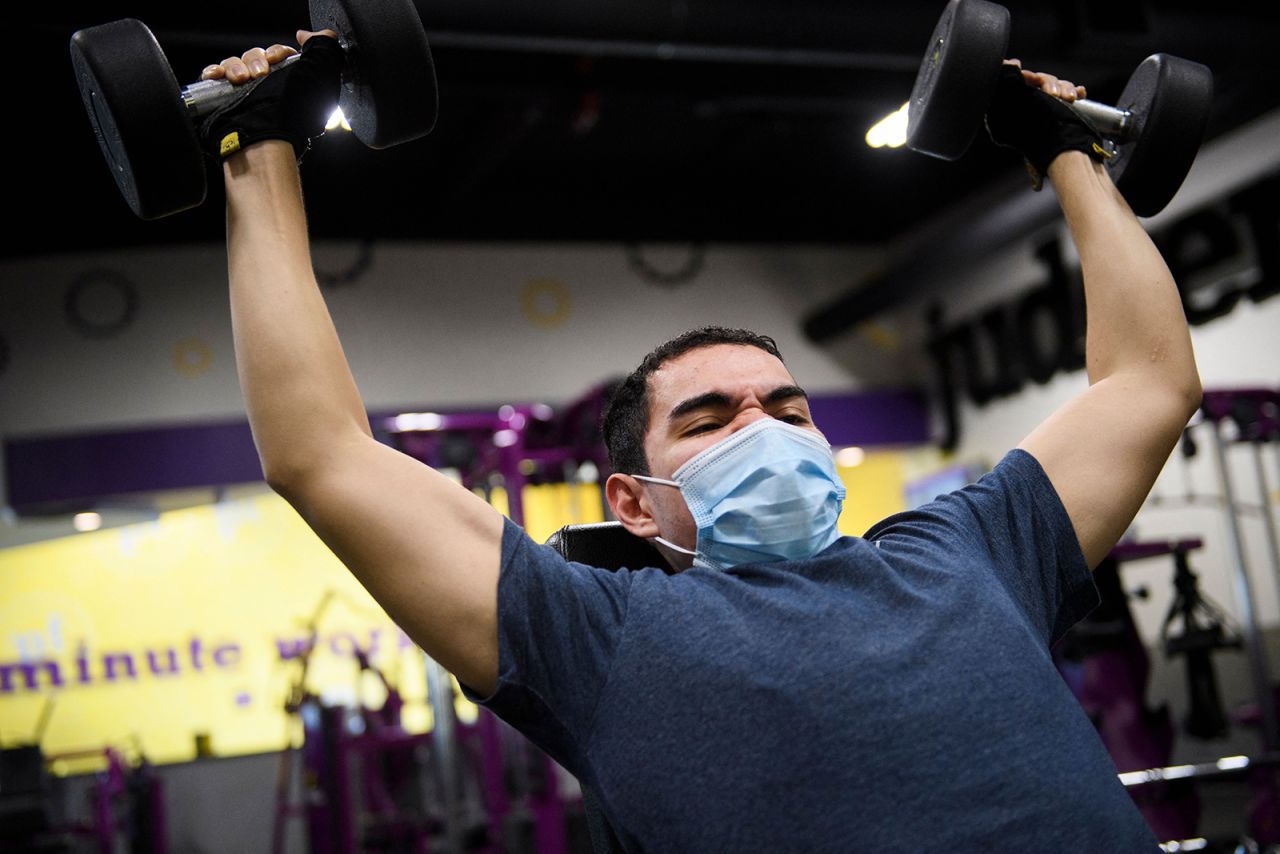 A customer wears a face mask as they lift weights inside a Planet Fitness Inc. gym on March 16, in Inglewood, California. 