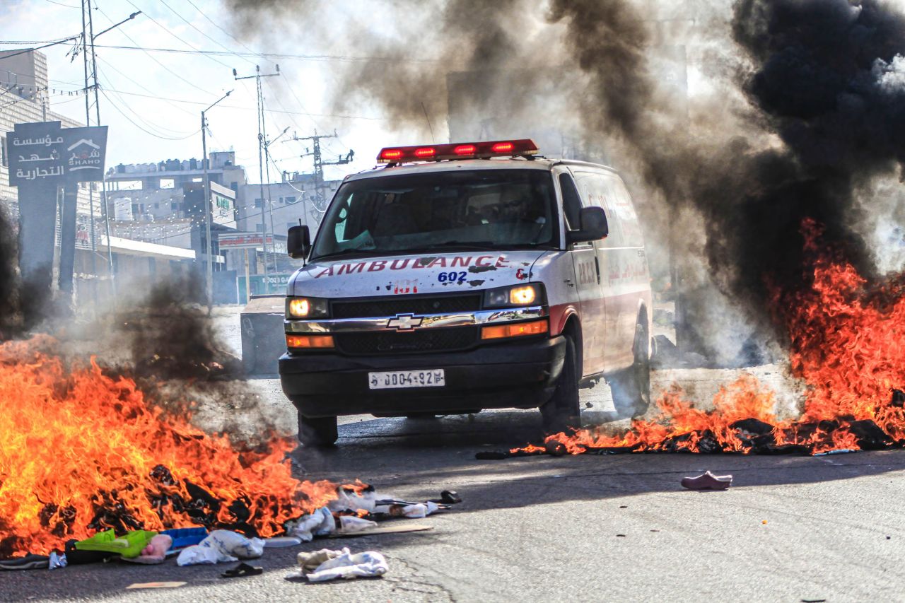 An ambulance passes through flames while transporting an injured Palestinian, during a demonstration in support of Gaza, in Nablus, West Bank, on October 13.