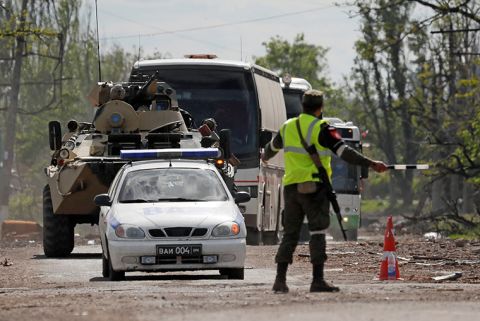 Buses carrying Ukrainian service members are escorted away from the Azovstal steel  plant by the pro-Russian military in Mariupol, Ukraine on Tuesday, May 17. 