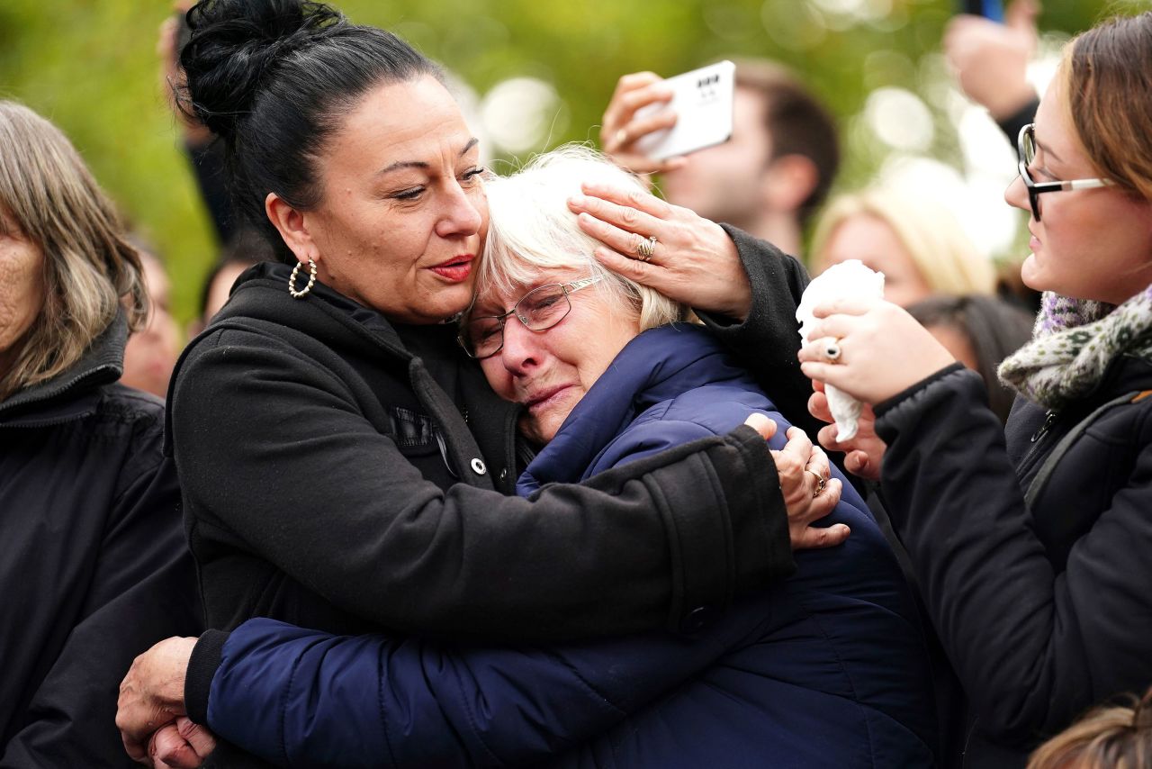 A woman is embraced as the State Gun Carriage carrying the coffin of Queen Elizabeth passes by during the Ceremonial Procession following her State Funeral at Westminster Abbey in London on Monday. 