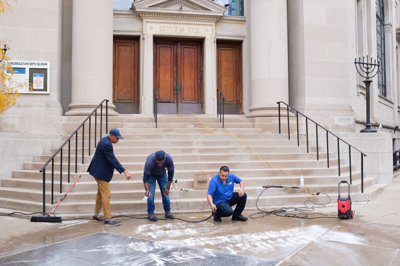 Workers clean graffiti from the sidewalk in front of Congregation Beth Elohim synagogue on 8th Avenue in Park Slope, Brooklyn, New York City on October 27. 