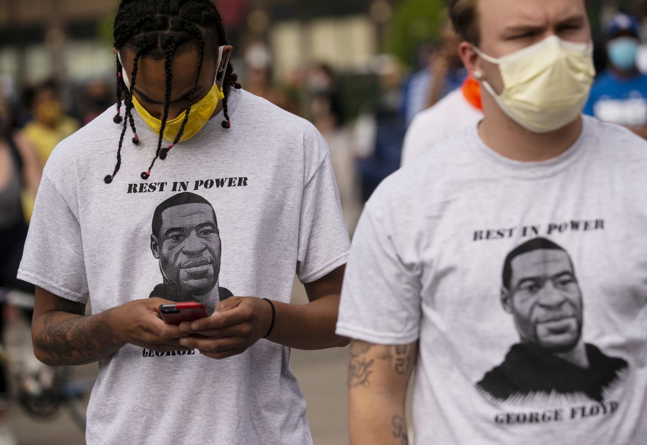 Two men wear shirts stating "Rest in Power George Floyd" outside the Third Police Precinct in Minneapolis, Minnesota,?on May 27, 